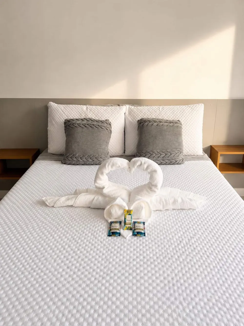 Cama de casal arrumada com toalhas dobradas no apartamento da Bela Vista