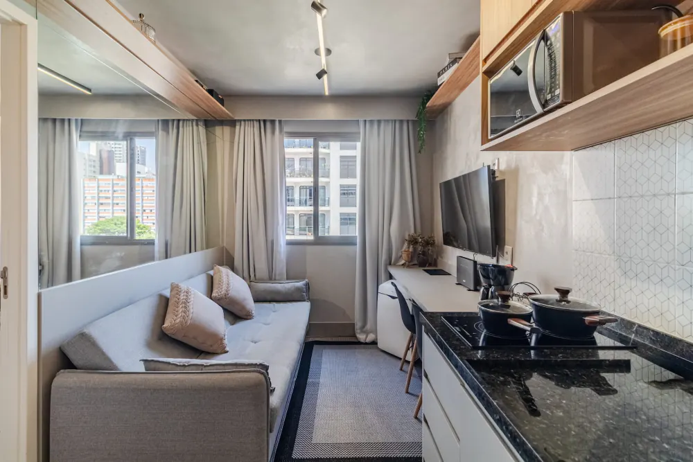 Sala com sofá, bancada e TV perto da Faria Lima
