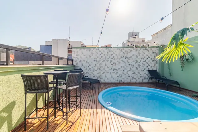 Terraço com piscina privativa, mesa alta e espreguiçadeiras